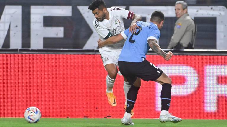 Jesús Manuel “Tecatito” Corona intenta esquivar a José Giménez.