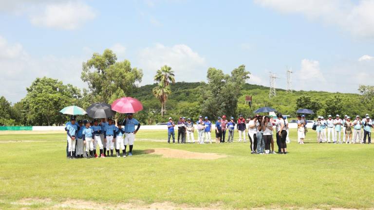 Los asistentes se protegen del fuerte sol durante el acto.