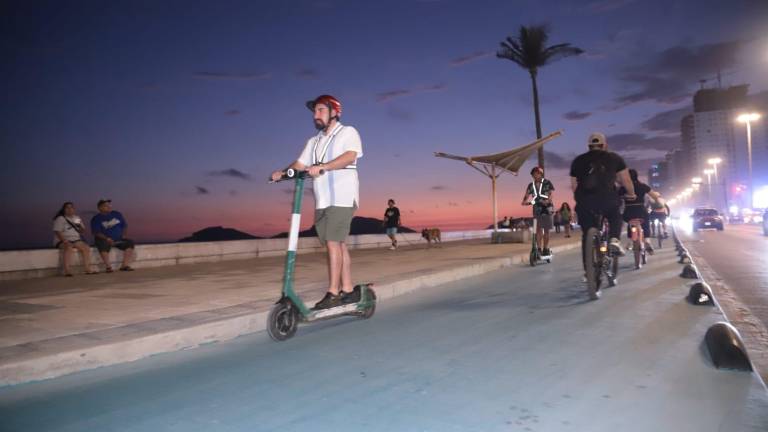 Familias y turistas disfrutan del malecón en scooters y bicicletas, cada vez más conscientes de las medidas de seguridad.
