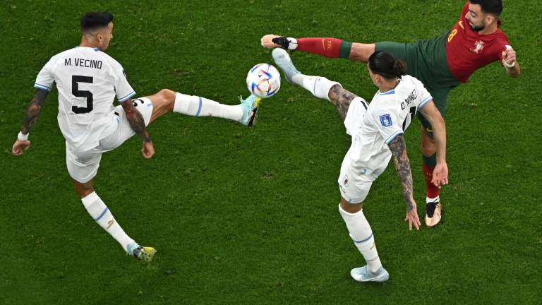 Bruno Fernandes, quien aquí disputa el esférico ante dos uruguayos, anotó los dos goles de Portugal.