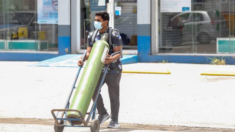José camina todos los días con un tanque de oxígeno que transporta en un “diablito” para su abuelo enfermo de Covid.