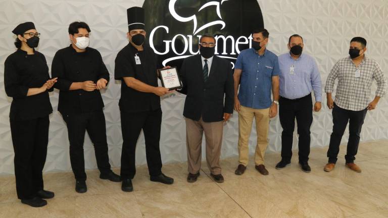 Adrián López, chef de Gourmet Cimaco recibe el reconocimiento de Mario Villegas, gerente general del hotel Playa Esperanza Boutique Resort, en Celestino Gazca.