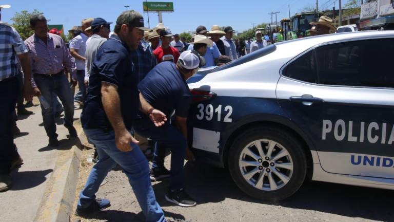 Los agricultores intentaron mover una patrulla con sus manos para acceder con sus vehículos, pero desistieron.