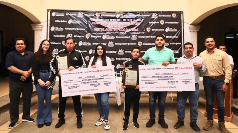 El entrenador Néstor Agustín Picos Sanabria y el taekwondoí Francisco Campaña Rocha, con sus premios al lado de las autoridades.