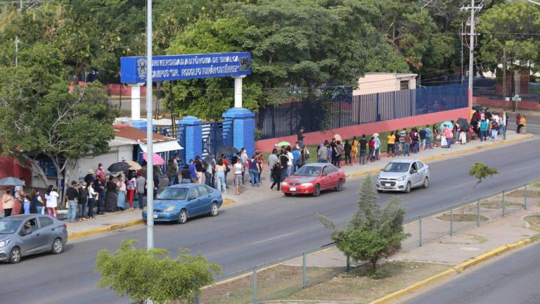 La fila del Polideportivo da la vuelta a la cuadra como sucede al inicio de cada jornada y en esta ocasión se puede observar que todos los asistentes usan su cubrebocas.