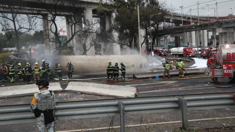 Personal de emergencia controla el fuego tras la explosión de una pipa de gas.