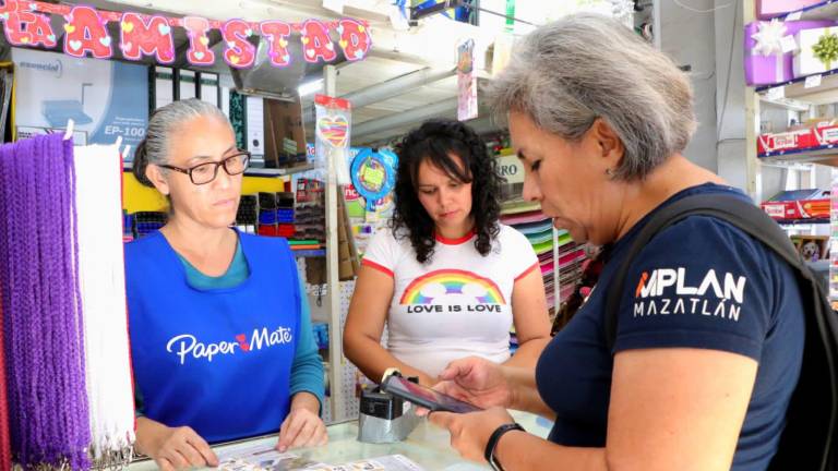 La directora del IMPLAN, Leticia Alvarado, entrega volantes para socializar el proyecto del carril preferencial para transporte urbano en Mazatlán, mientras Tránsito ya aplica multas.