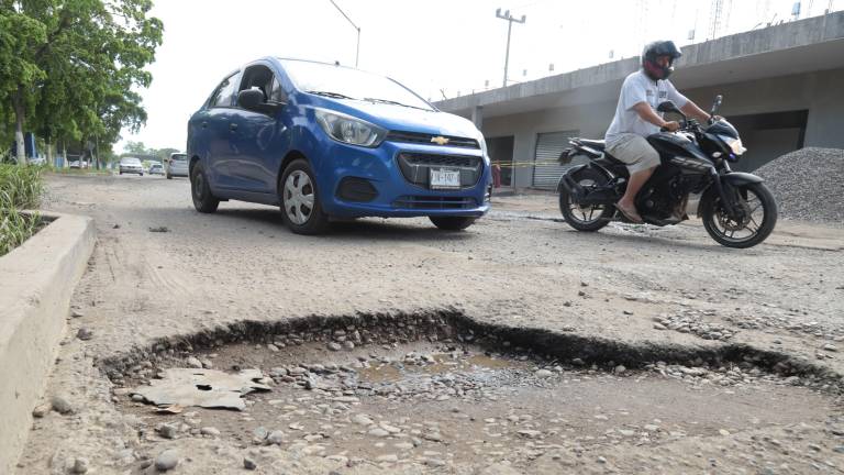 Enormes baches son esquivados por los vehículos que transitan por la avenida Manuel J. Clouthier.
