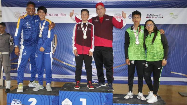 Luis Zavala posa en lo más alto del podio junto a su entrenador, tras lograr la medalla de oro.