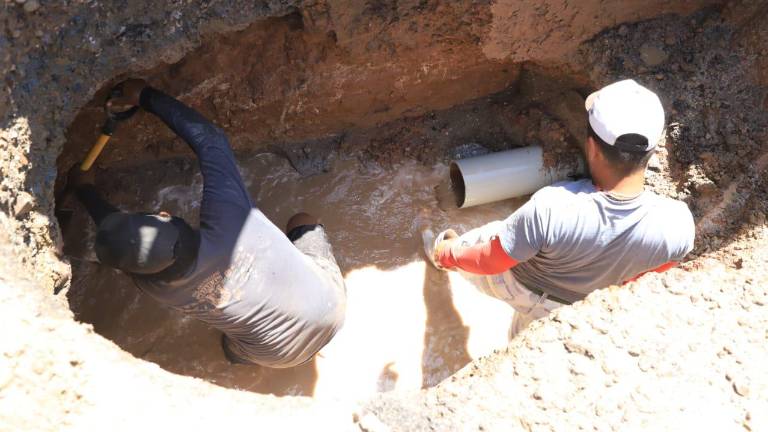 Los trabajadores de Jumapam trabajan para reparar el tubo.