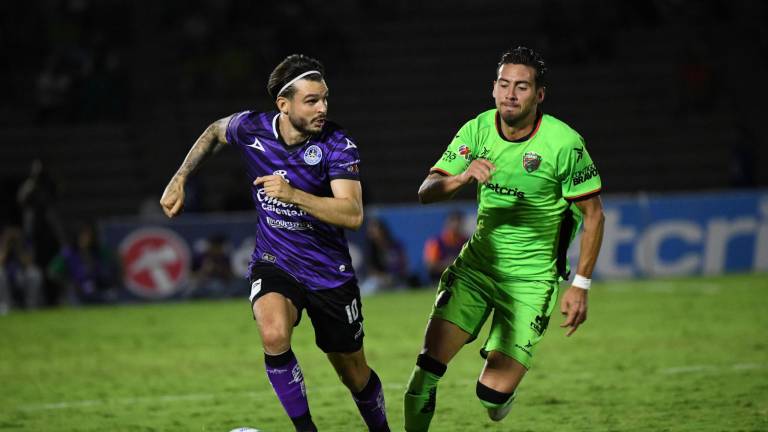 Nicolás Benedetti conduce el balón ante la marca de Javier Salas.