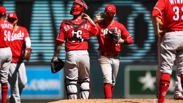 Tucker Barnhart y Tyler Naquin, quienes aquí festejan, conectaron jonrón por los Rojos de Cincinnati.