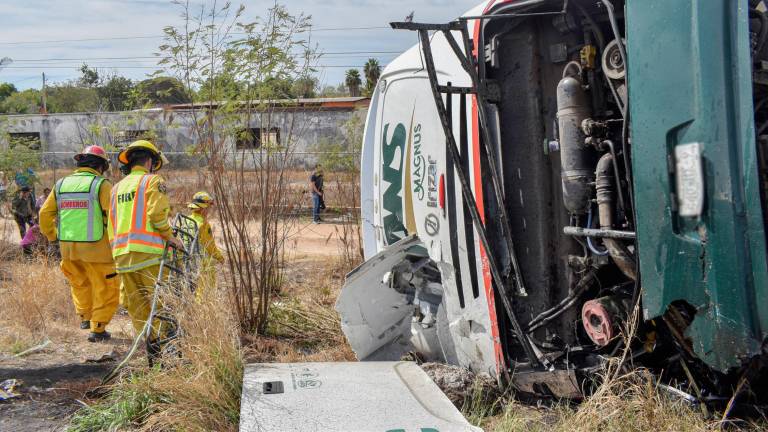 El autobús de pasajeros y el tráiler quedaron volcados hacia los costados de la carretera tras impactarse por alcance.