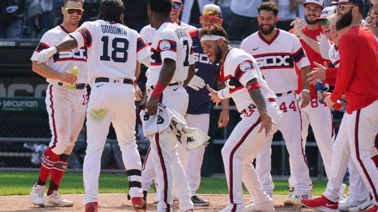 Brian Goodwin es recibido por sus compañeros en el home tras dar el jonrón del triunfo.