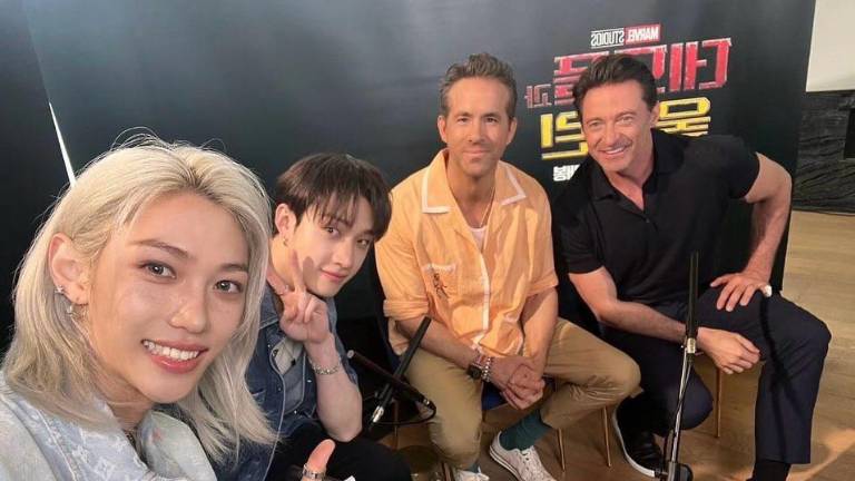 Félix y Bang Chan, integrantes de Stray Kids, con los actores Ryan Reynolds y Hug Jackman.
