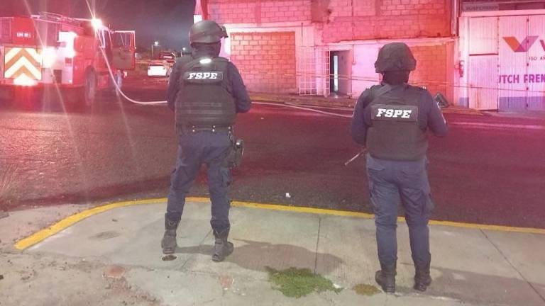 Elementos de seguridad inspeccionan los trabajos de atención al incendio registrado en un anexo.