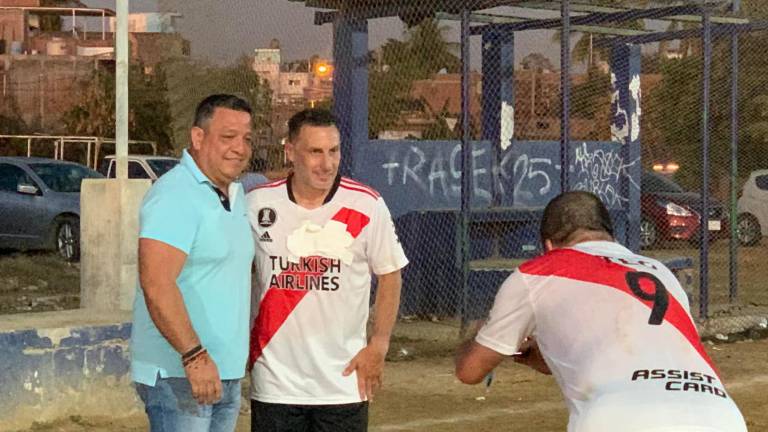 Christian “Chaco” Giménez (der.) posa con un aficionado tras el juego.