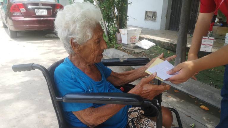 La señora Rita Orozco recibe el donativo que lectores han querido hacerle llegar.