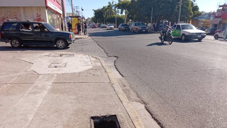 Alcantarilla profunda y sin tapadera en la banqueta de la Avenida Ejército Mexicano, casi esquina con Flamingos, en el Fraccionamiento Lomas del Mar. A unos metros de distancia está otra y una varilla levantada.