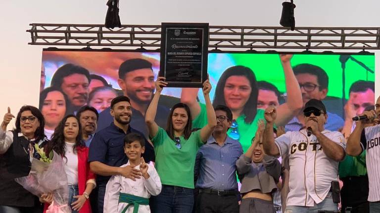 María del Rosario Espinoza recibe su placa de reconocimiento de manos del Alcalde Martín Ahumada.