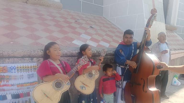 Familia huichol llega a Mazatlán para compartir su música, tradiciones y artesanías, y sacar algo de dinero.