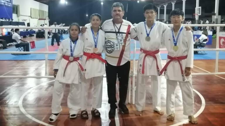 El entrenador Jesús Moreno es escoltado por sus pupilos medallistas.