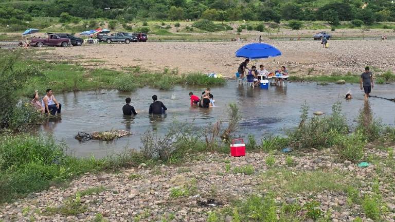 Las familias disfrutan bañarse en el río.
