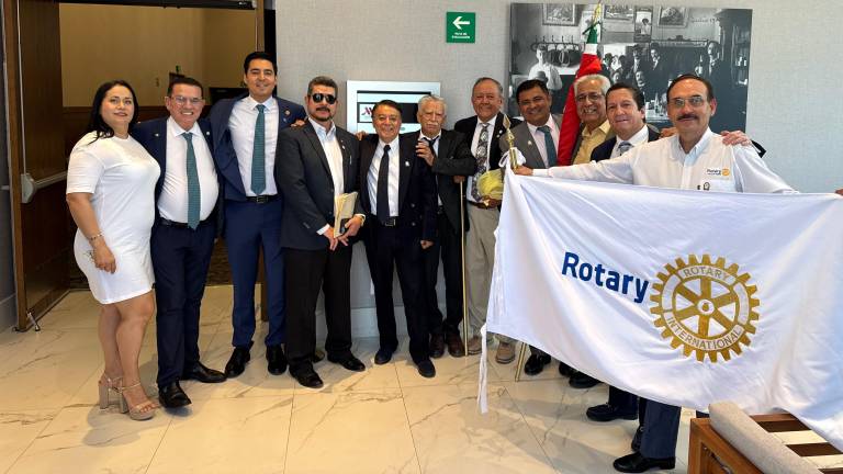 Miembros del Club Rotario Culiacán Oriente extienden con orgullo el estandarte del club.