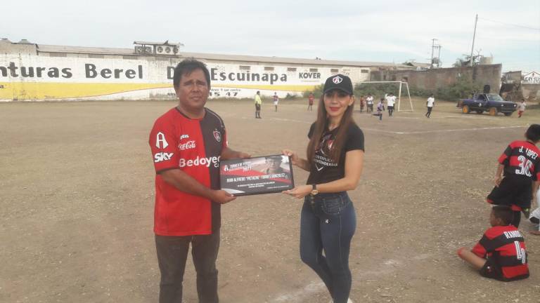 Almendra Torres, nieta del homenajeado Alfredo Torres, recibe el reconocimiento de su abuelo.