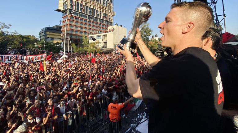 Julio Furch muestra el trofeo de campeón a la afición del Atlas, luego de concluir el desfile.