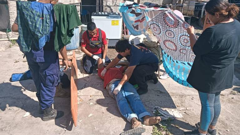 Un hombre es atendido por personal de emergencia tras caer del techo de una casa, en Escuinapa.