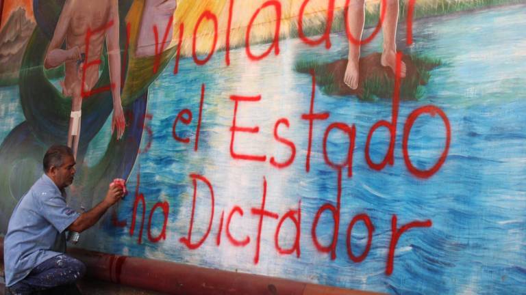 Personal de Palacio de Gobierno realiza la limpieza de las pintas que realizaron colectivas feministas.