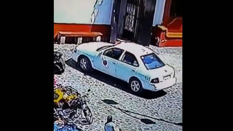 En los videos se puede ver como una mujer y un hombre sacan bolsas negras que llevaron a guardar a la cajuela de un taxi.