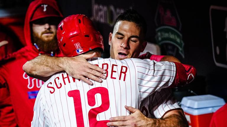 Kyle Schwarber es felicitado tras pegar uno de sus dos cuadrangulares para los Filis en el Juego 2.