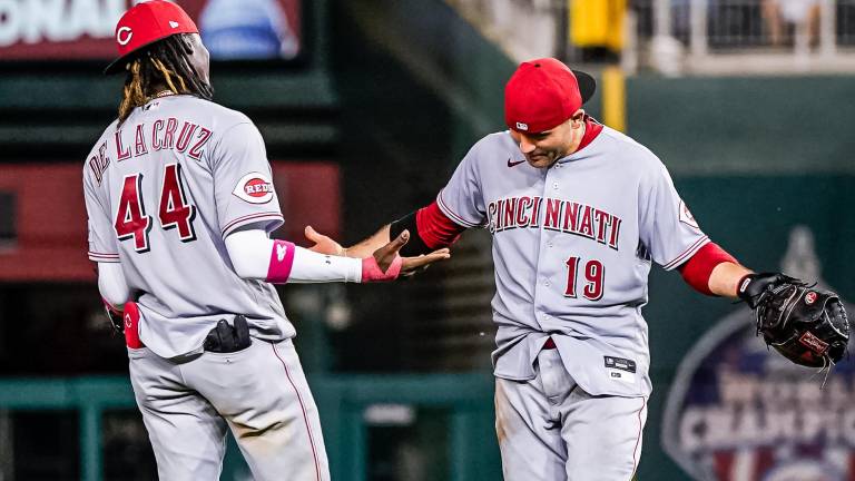 Joey Votto, quien dio jonrón clave, celebra la victoria con Elly de la Cruz.