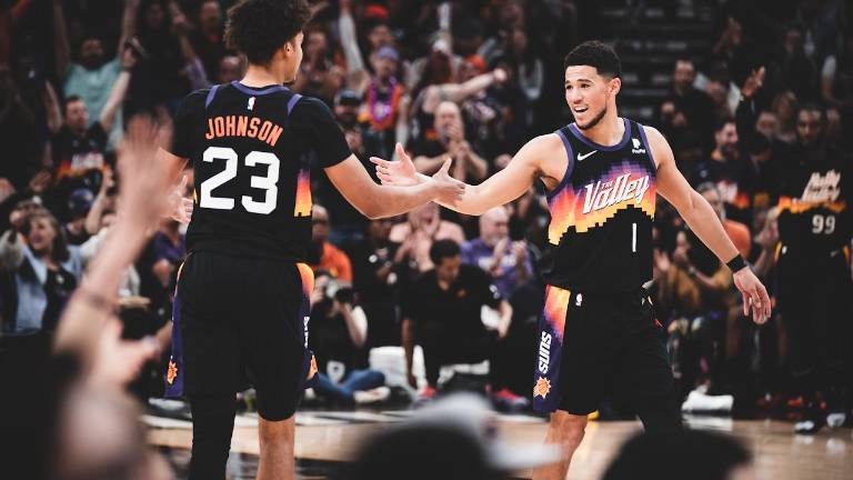 Devin Booker es felicitadoi por Cameron Johnson ante el júbilo de los aficionados.