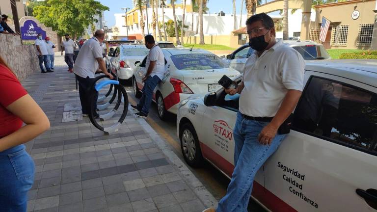 Choferes de Ecotaxis Rojos a las afueras de conocido hotel de la Avenida Playa Gaviotas.