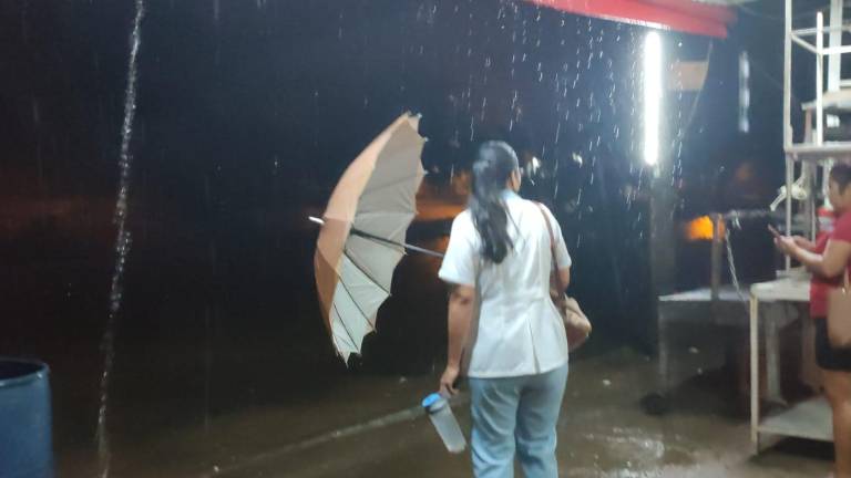 Dos mujeres esperan transporte para llegar a su centro de trabajo.