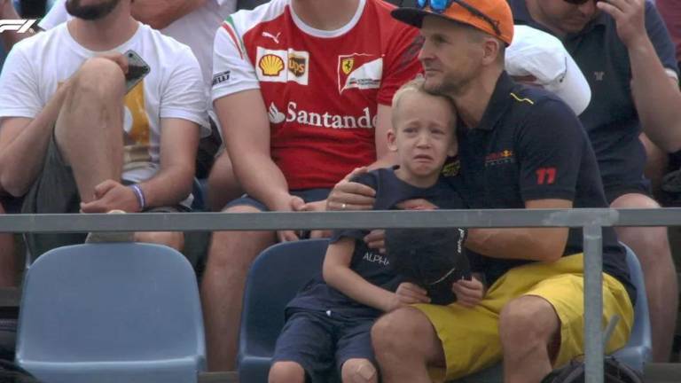 El pequeño es consolado por su padre.