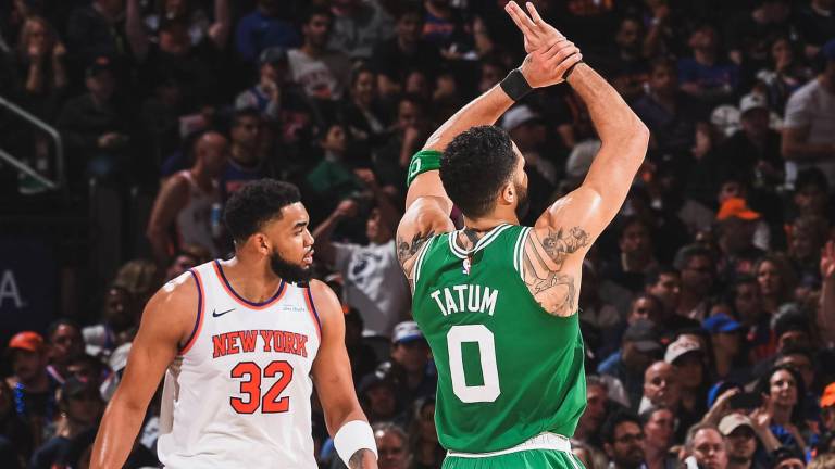 Jayson Tatum celebra puntos para los Celtics ante la mirada de Karl-Anthony Towns.