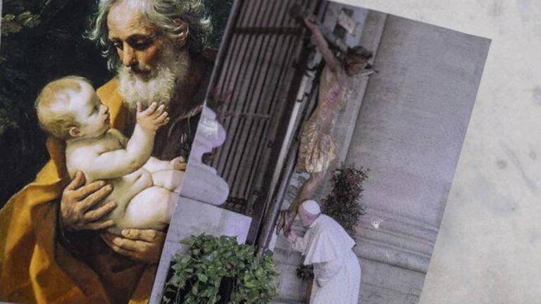 Imagen de San José y foto del Papa Francisco besando un crucifijo, afuera del hospital Gemelli