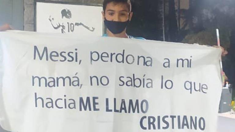 El niño muestra una manta con la disculpa por su nombre.