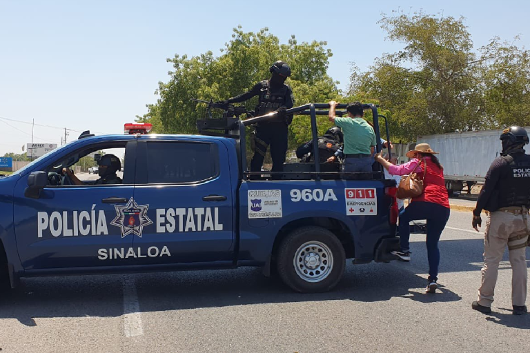 Policías estatales transportan a ciudadanos afectados por bloqueos en Culiacán