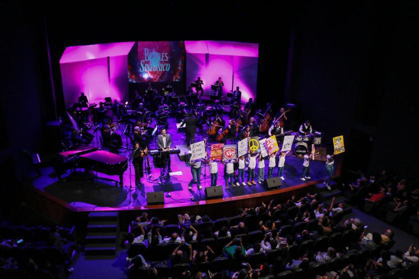 $!Un grupo de niños de blanco en el escenario, con pancartas pidiendo el regreso de la paz y pregonando el amor, participaron en ‘All you need is love’.