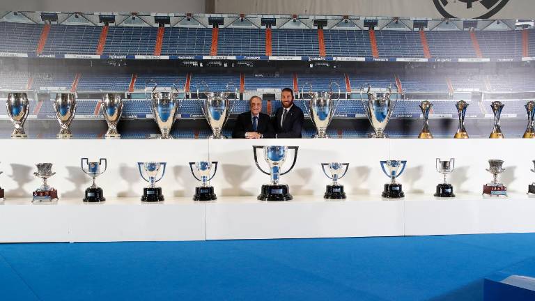 Sergio Ramos y Florentino Pérez posan juntos a los trofeos que el defensa ganó con los merengues.