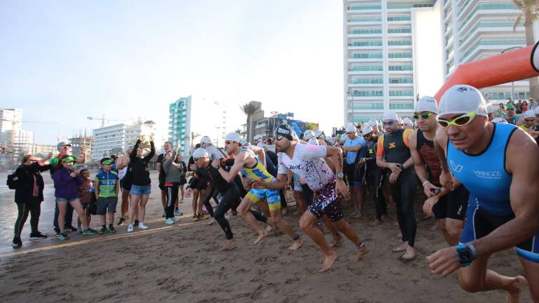 Los primeros triatletas salen de la prueba de natación.