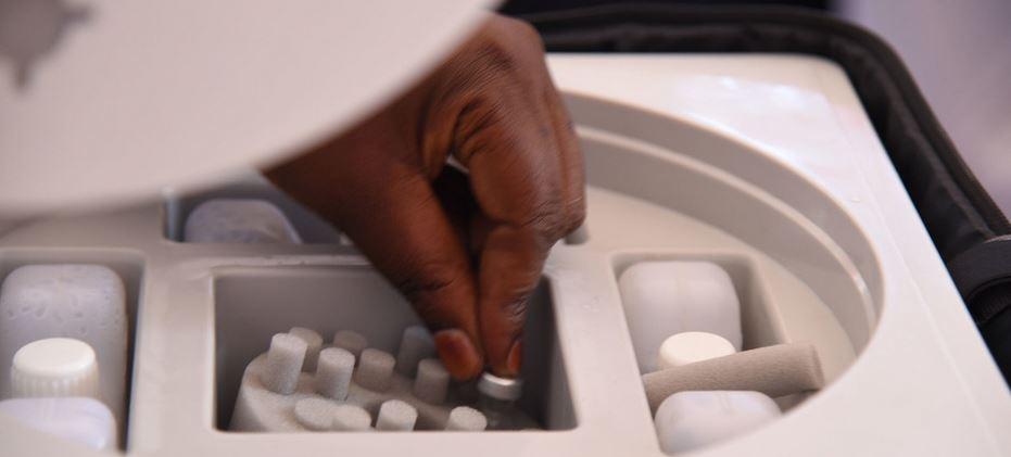 $!Un trabajador sanitario recoge un vial de la vacuna COVID-19 de AstraZeneca de un recipiente refrigerado en Uganda.
