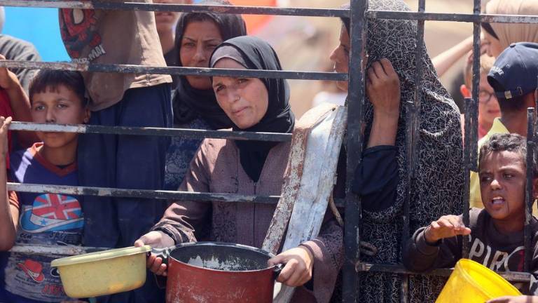 Mujeres y niños esperando comida en una cocina comunitaria de la ciudad de Gaza.