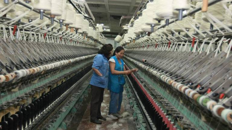 Dos mujeres revisan los telares de una fábrica de alfombras en Mongolia.