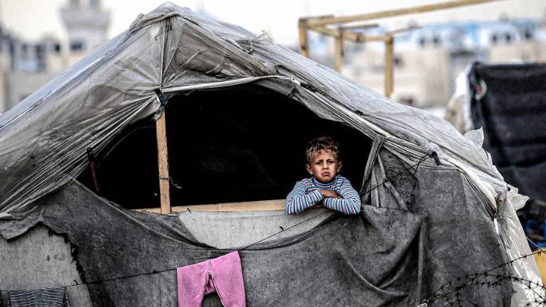 Un niño mira desde un refugio improvisado en Rafah, en el sur de la Franja de Gaza